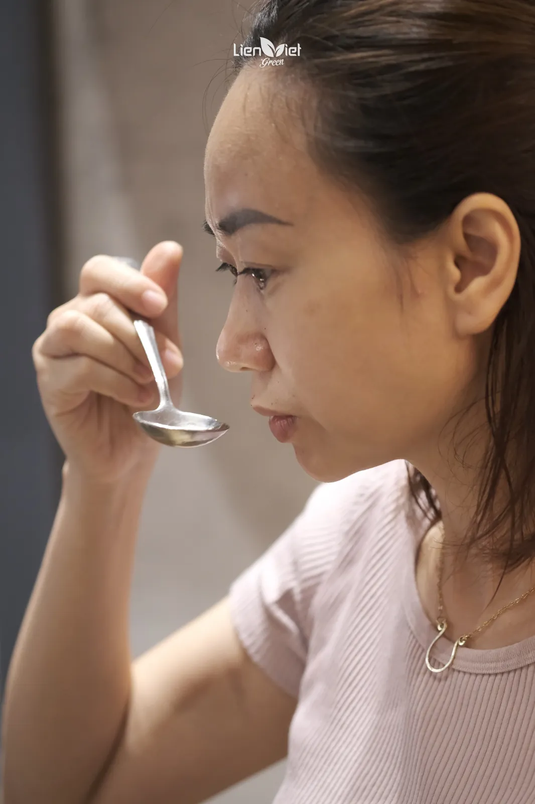 Chị Hương (Mayer Chan), Q Grader và chủ Công ty Liên Việt Xanh, đưa thìa cupping lên ngửi hương trong buổi cupping Fine Robusta
