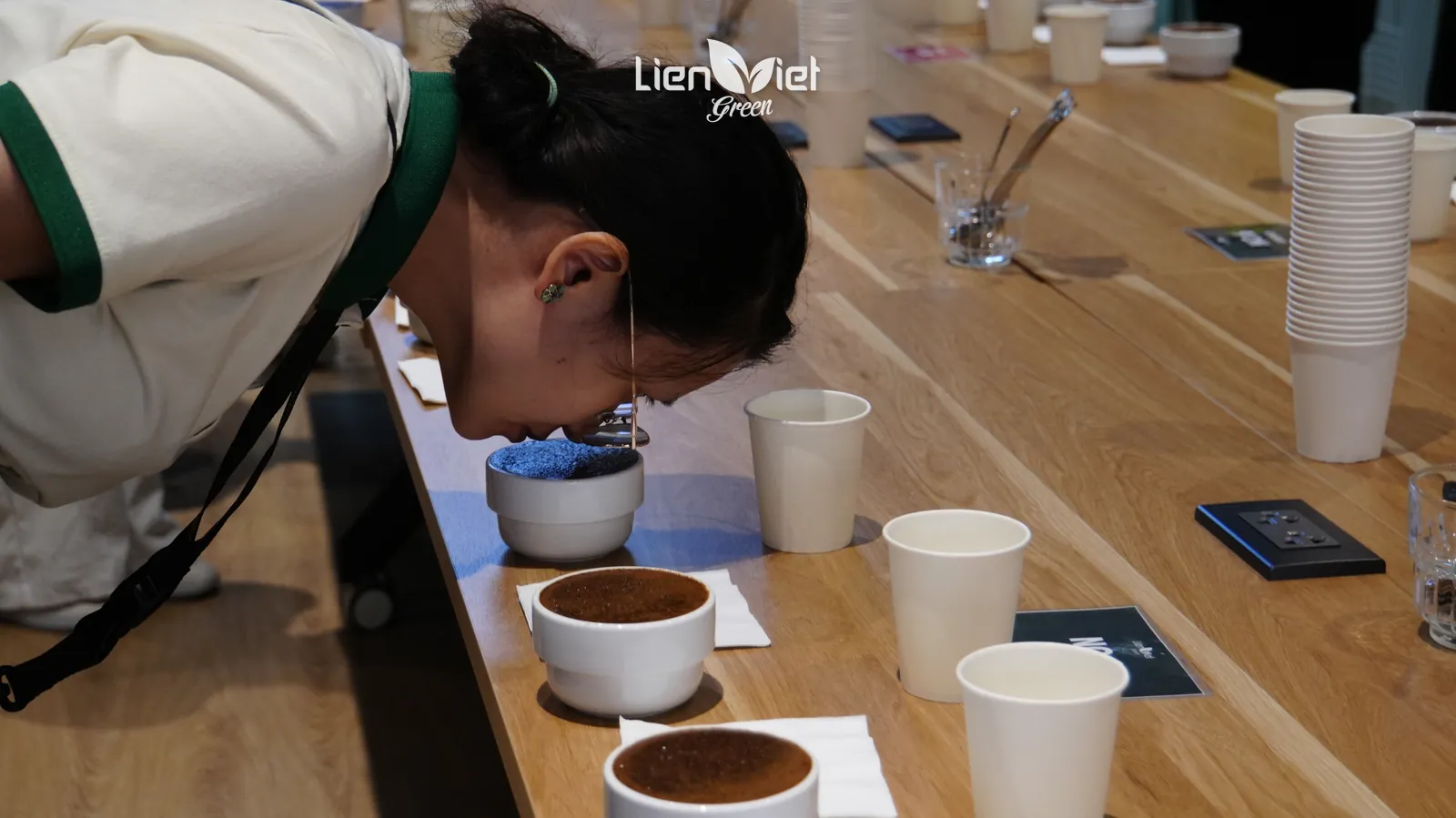 Guest smelling dry coffee grounds in a cupping bowl to pick out fermentation notes, at The New Crop harvest experience event