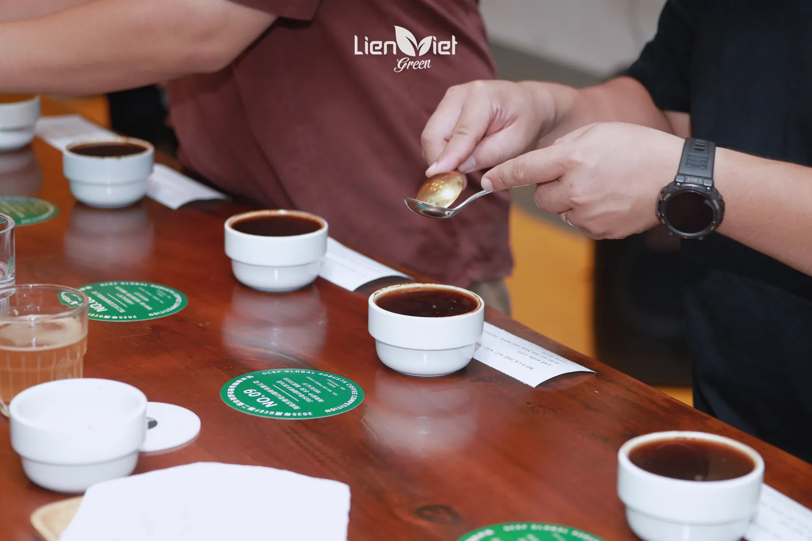 Cupping spoon over a row of sample bowls