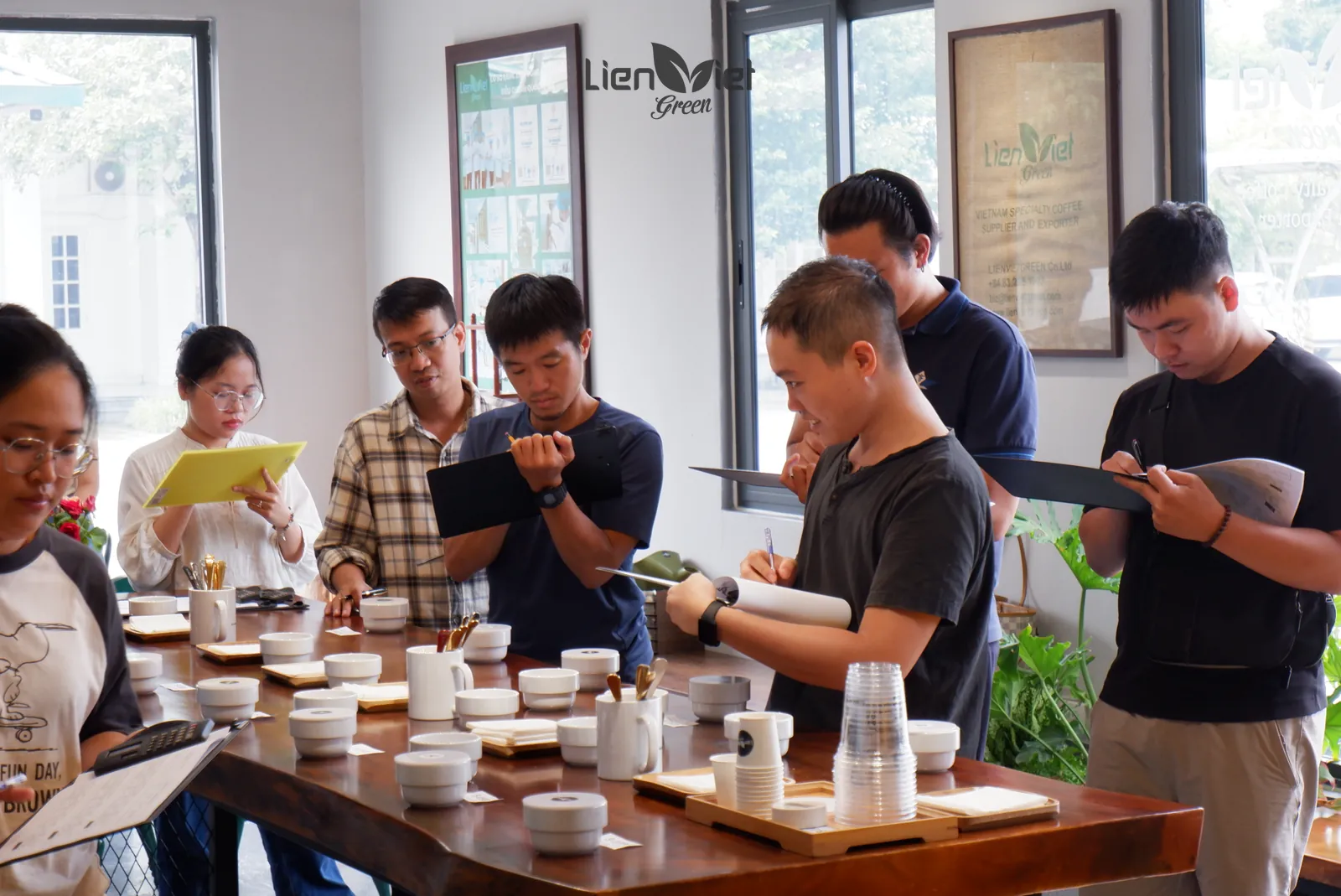Guests around a cupping table writing on score sheets