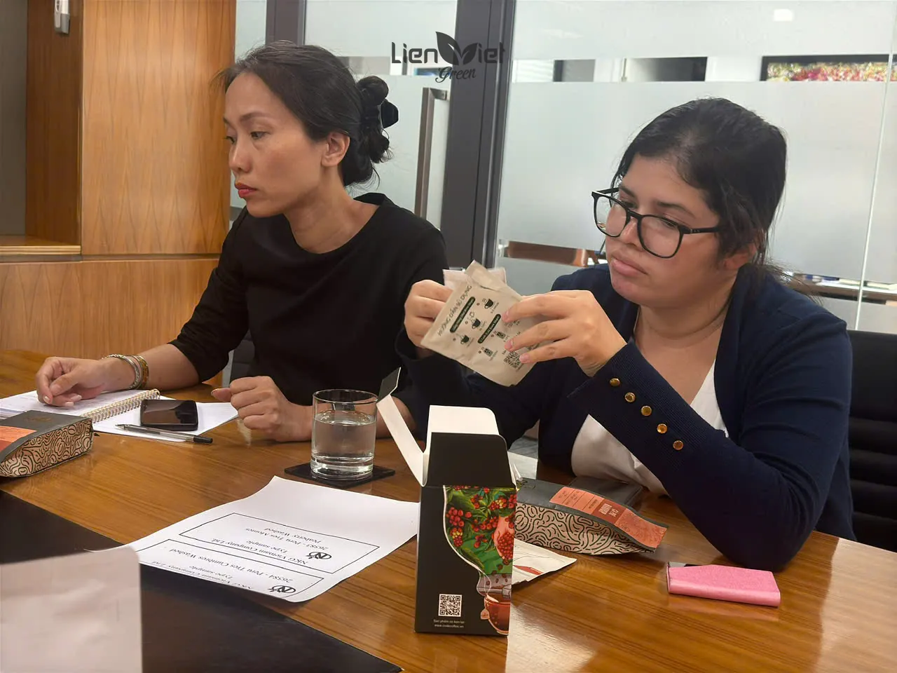 Representative of the Embassy of Peru examining a Lien Viet Green coffee sample at the meeting table