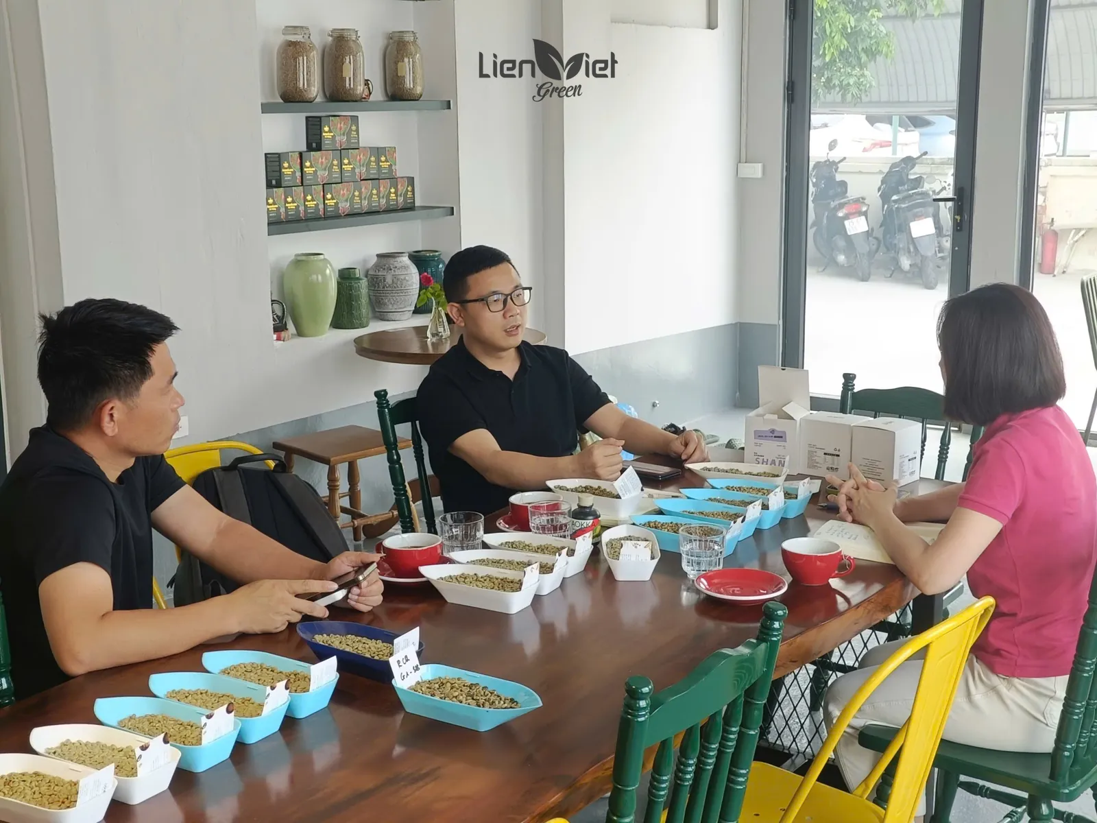 Chị Hương (Mayer Chan), chủ Công ty Liên Việt Xanh, cùng khách Trung Quốc phân tích các khay mẫu nhân xanh và chén thử từng lô, buổi làm việc ngày 5/6 tại Liên Việt Green