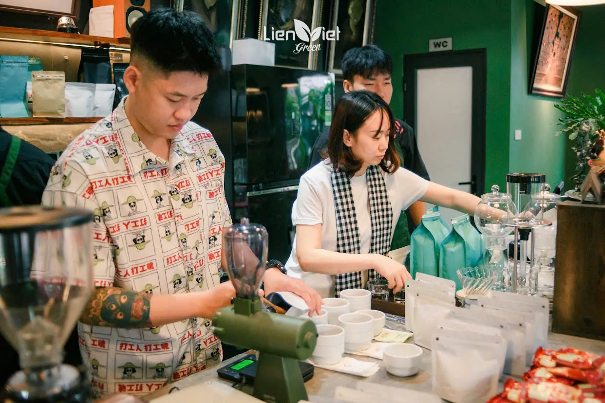 Barista grinding coffee and preparing sample cups at the bar