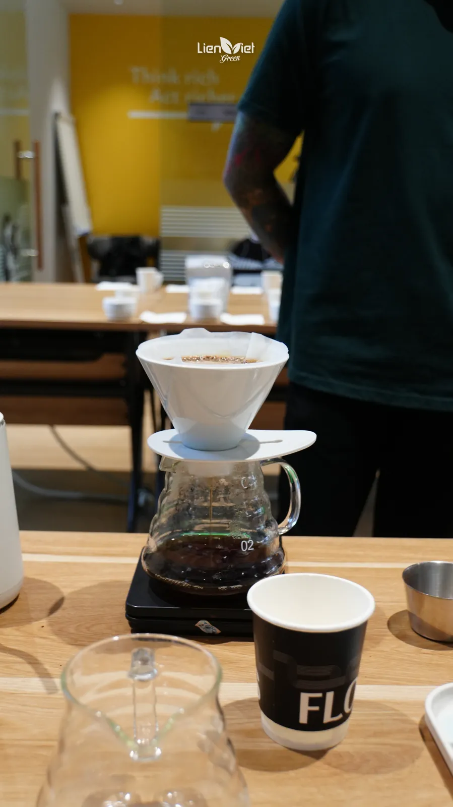 Pour-over coffee brewing through a V60 dripper on a glass server and digital scale