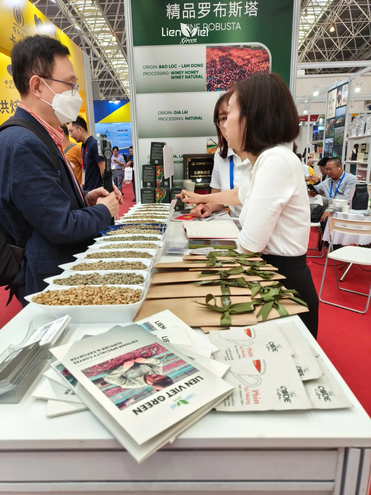 Ms Huong (Mayer Chan), founder of Lien Viet Green, presenting green coffee sample bowls to visitors at Cofair 2025
