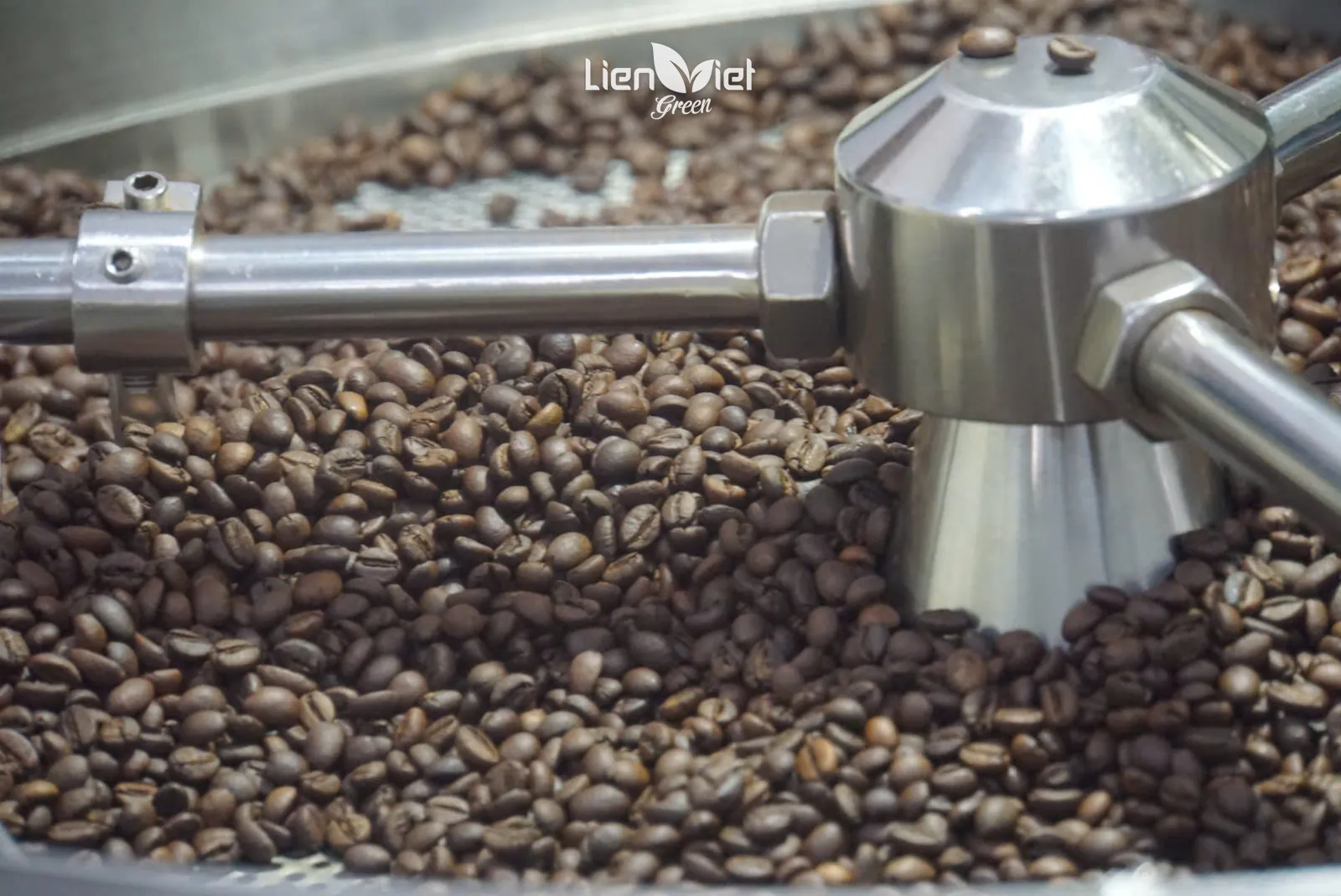 Cận cảnh cần đảo inox trên mâm làm nguội đầy hạt vừa rang